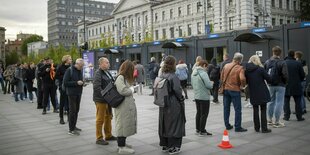 Menschen stehen vor einem Gebäude Schlange