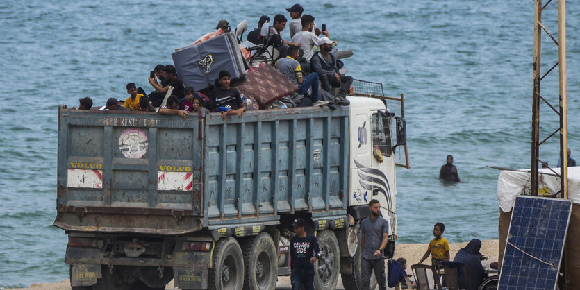 Menschen auf der Ladefläche eines Lastwagens