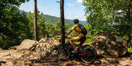 Ein Mountainbiker macht Pause und schaut über den Pfälzerwald.