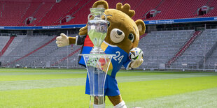 Albärt, Maskottchen der Fußball-EM 2024, steht bei der Präsentation des Fußball-EM-Pokals in der Allianz Arena in München