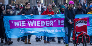 Demonstranten mit einem Plakat mit der Aufschrift: "Nie wieder ist jetzt"