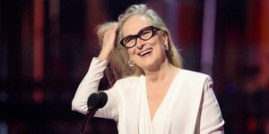 Meryl Streep (Eine Frau mit langen Haaren) steht vor einem Mikro