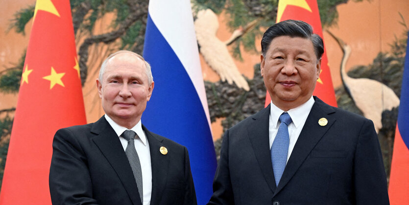 Wladimir Putin und Xi Jinping schütteln die Hände