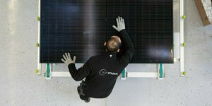 Ein Arbeiter an einem Solarmodul