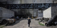 Ein Arbeiter vor einem beschädigten Kraftwerk