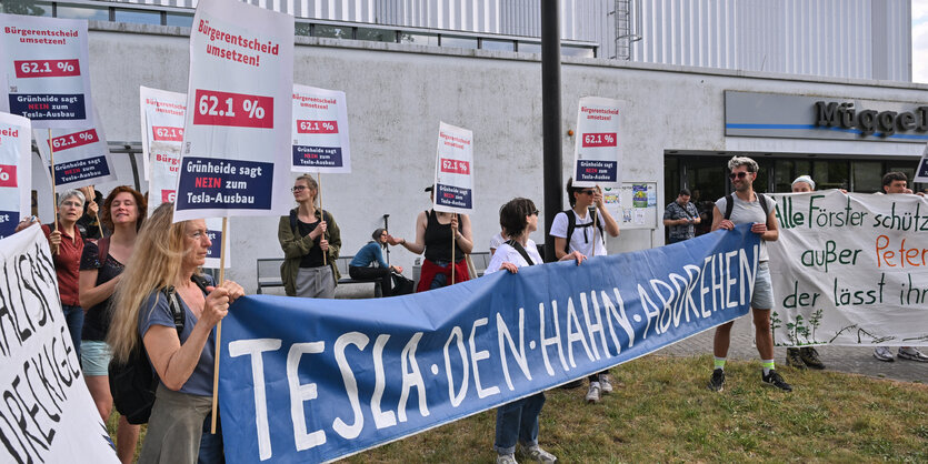 Menschen mit Transparent vor Fabrikgebäude