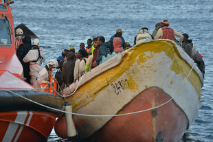 Zu sehen ist ein Boot mit Menschen auf der Flucht