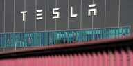 Das Foto zeigt den Schriftug des US-Autobauers Tesla an der Fassade seiner Fabrik in Grünheide östlich von Berlin