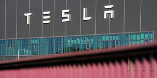 Das Foto zeigt den Schriftug des US-Autobauers Tesla an der Fassade seiner Fabrik in Grünheide östlich von Berlin