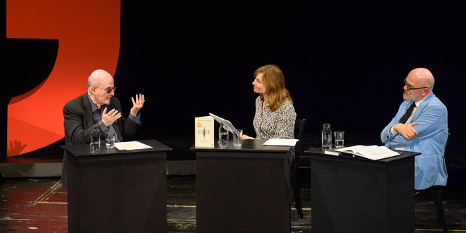 Drei Menschen sitzen auf einem Podium, v. l. : Salman Rushdie, Marie Kaiser, Thomas Böhm