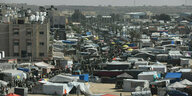 Mitten in Rafah, ein Zeltlager für vertriebene Palästinenser, Zelt steht an Zelt, viele Menschen drängen sich in einer Gasse zwischen den Zelten.
