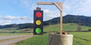 Ampel an einem Galgen mit Heuballen neben einer Landstrasse