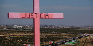 Auf einem rosafarbenen Kreuz steht „Justicia“