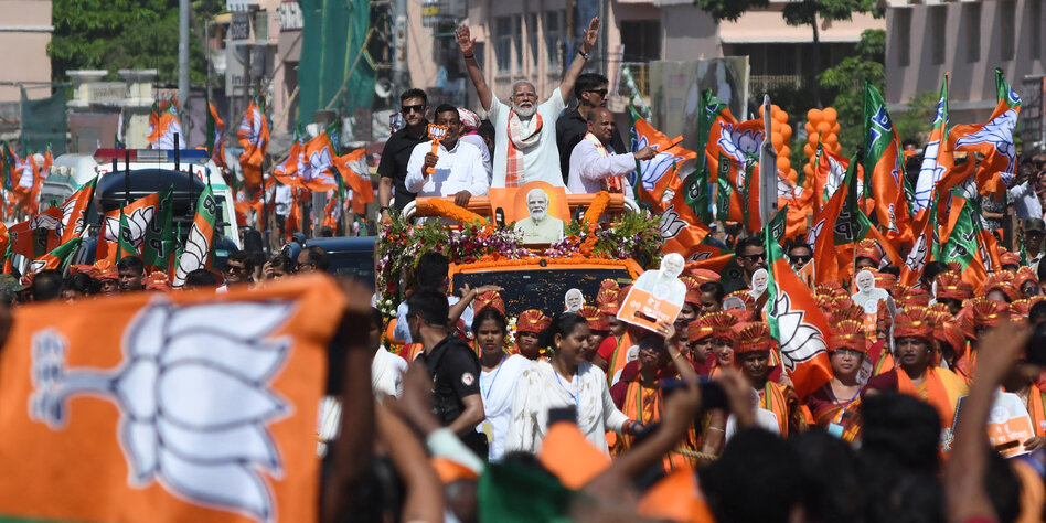 Indiens Premierminister Modi fährt mit Siegerpose auf einem Wagen durch eine Menschenmenge