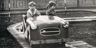 Zwei Kinder in einem Elektroauto auf einem Rummel Leipzig