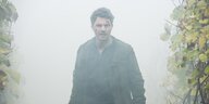 Hauptdarsteller Friedrich Mücke steht einsam zwischen Weinreben umgeben von Nebel