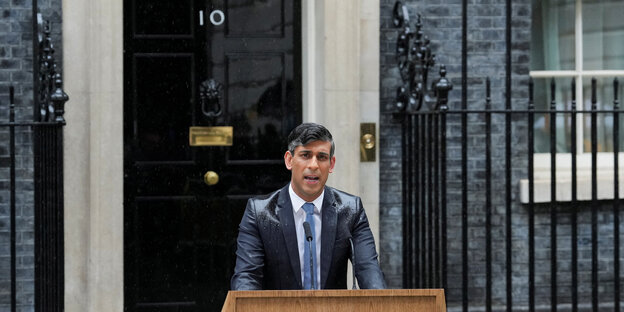 Rishi Sunak steht durchnässt am Redepult vor der Tür von Downing Street 10