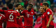 FC Bayern-Spieler stehen rum und klatschen sich ab