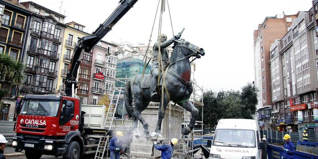 Eine Statue des Diktators Franco wird mit einem Kran abtransportiert