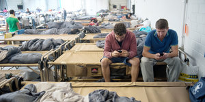Flüchtlinge sitzen in einer Notunterkunft in Stuttgart