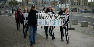 Klimaaktivist Wolfgang Metzeler-Kick (M) geht mit Unterstützern nach an einer Pressekonferenz im Hungerstreik-Camp durch das Regierungsviertel