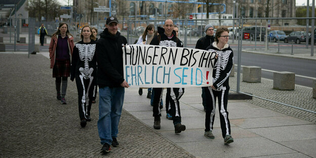 Klimaaktivist Wolfgang Metzeler-Kick (M) geht mit Unterstützern nach an einer Pressekonferenz im Hungerstreik-Camp durch das Regierungsviertel