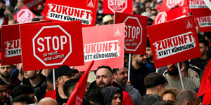 Thyssenkrupp-Stahlarbeiter demonstrieren mit roten Stoppschildern