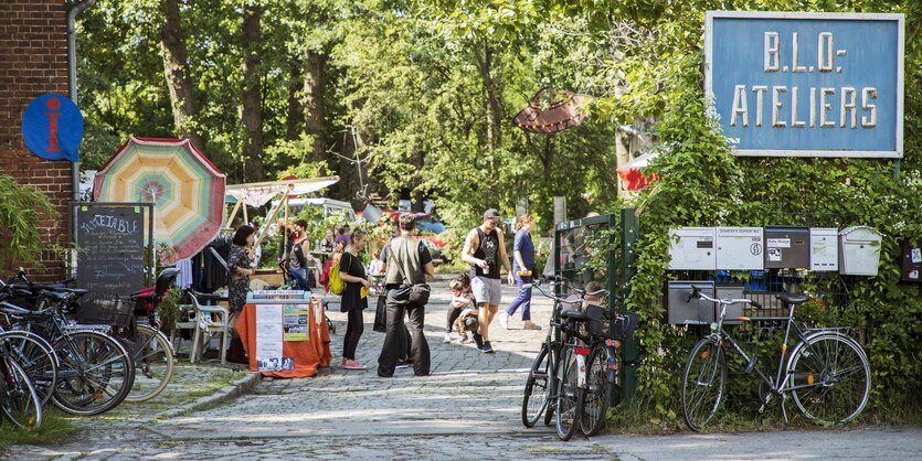 Eingang zu den B.L.O.-Ateliers mit Menschen und spielenden Kindern