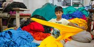 Ein Kind arbeitet an Kleidungsstücken in einer örtlichen Konfektionsfabrik