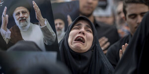 Eine trauernde Iranerin in einer Menchenmenge.