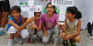 Vier Mädchen halten Schildern „Freedom“, „Life or die“ hoch