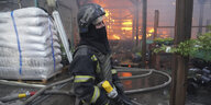 Ein Feuerwehrmann vor dem von einem russischen Luftangriff getroffenen Baumarkt