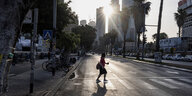 Eine Frau überquert eine Straße in Tel Aviv