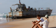 Ein US-Schiff, das Hilfslieferungen in den Gazastreifen bringen sollte, ist im israelischen Ashdod gestrandet. Davor entspannen sich zwei Menschen am Strand