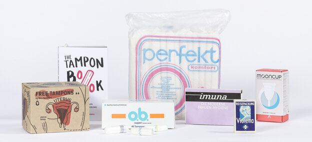 Menstruationsprodukte aus verschiedenen Epochen in ihrer Verpackung, alle sind in der Ausstellung 