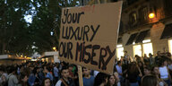 "Euer Luxus, unsere Misere" steht auf dem Schild einer Protestierenden in Mallorca