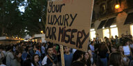 Your luxury, our misery steht auf einem Pappschild, das Demosntranten auf Mallorca hochhalten