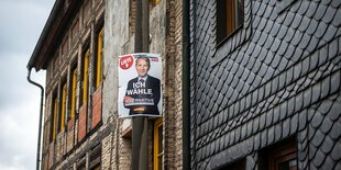 Ein leeres Rednerpult in blau-weiß mit dem Logo der AfD im Hitergrund