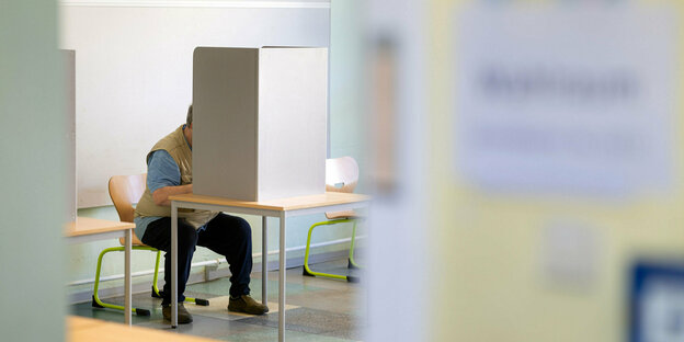 Ein Mann gibt bei der Kommunalwahl in Thüringen seine Stimme in einem Wahllokal ab.