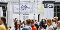 Besucher:innen der Medienmesse re:publica vor der Station Berlin im Gleisdreickpark