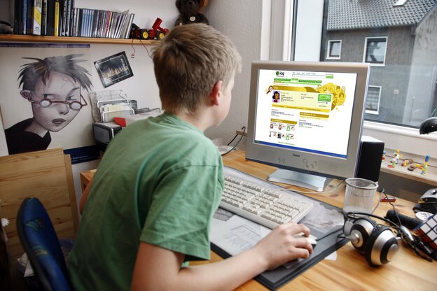ein Jungs sitzt im Kinderzimmer am Computer