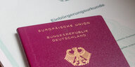 Ein deutscher Pass liegt auf einer Einbürgerungsurkunde