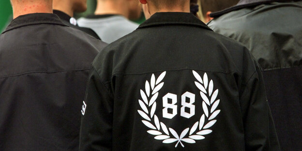 Ein Teilnehmer einer Demonstration trägt eine Jacke mit dem Aufdruck '88' in einem Lorbeerkranz.