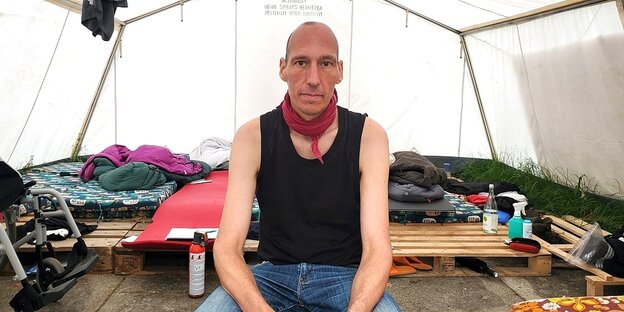 Portrait von Wolfgang Metzeler-Kick, der in einem großen Zelt sitzt