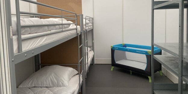 Blick in eine "Schlafwabe" im Ankunftszentrum Tegel: Doppelstockbetten und ein Kinderbett