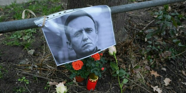 Ein Portrait des russischen Regimegegners Nawalny hängt an einem zaun