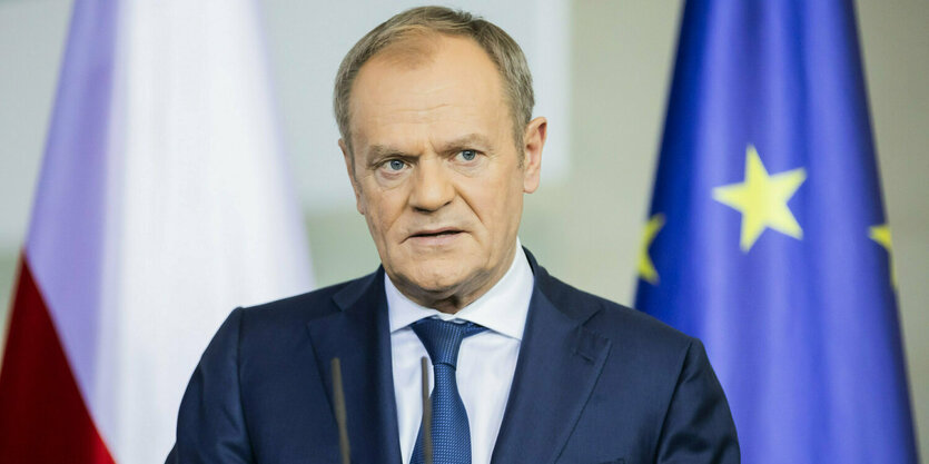 Der polnische Ministerpräsident Donald Tusk steht an einem Rednerpult.