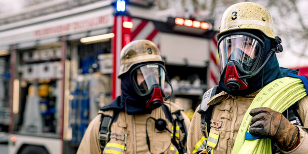 Zwei Feuerwehrleute in voller Montur mit Atemschutz