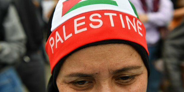 "Palestine" (Palästina) steht auf der Kopfbedeckung einer Teilnehmerin bei einer pro-palästinensischen Demonstration in Kreuzberg, Berlin.