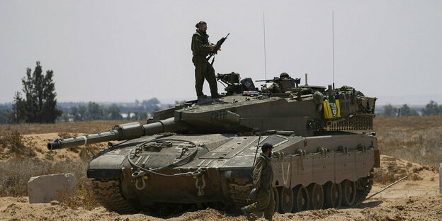 Ein Soldat steht auf einem Panzer